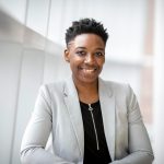 Confident African American businesswoman smiling inside a modern office space.